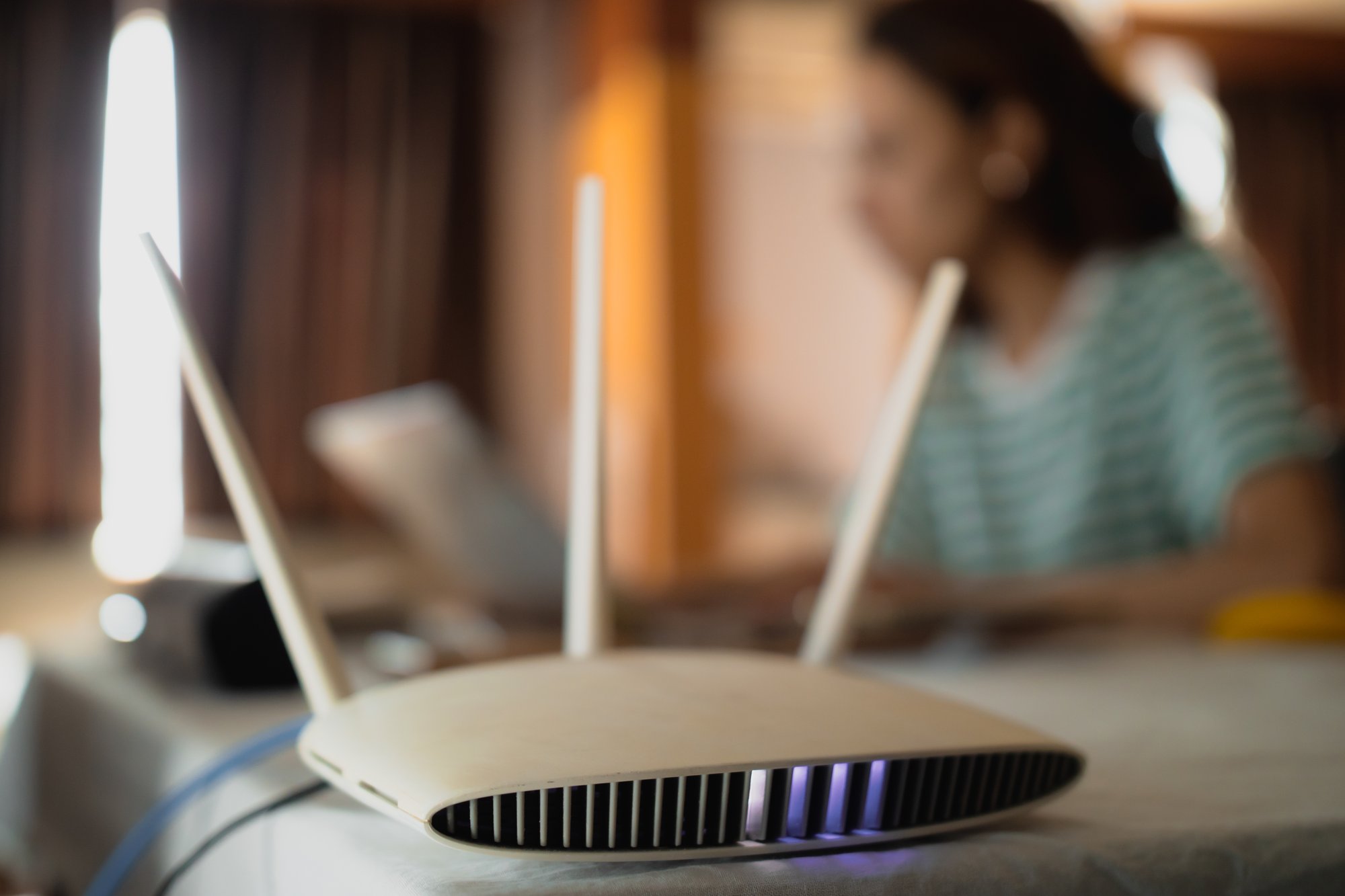 a-woman-is-working-at-home-using-a-modem-router-c-2023-11-27-05-10-14-utc a-woman-is-working-at-home-using-a-modem-router-c-2023-11-27-05-10-14-utc
